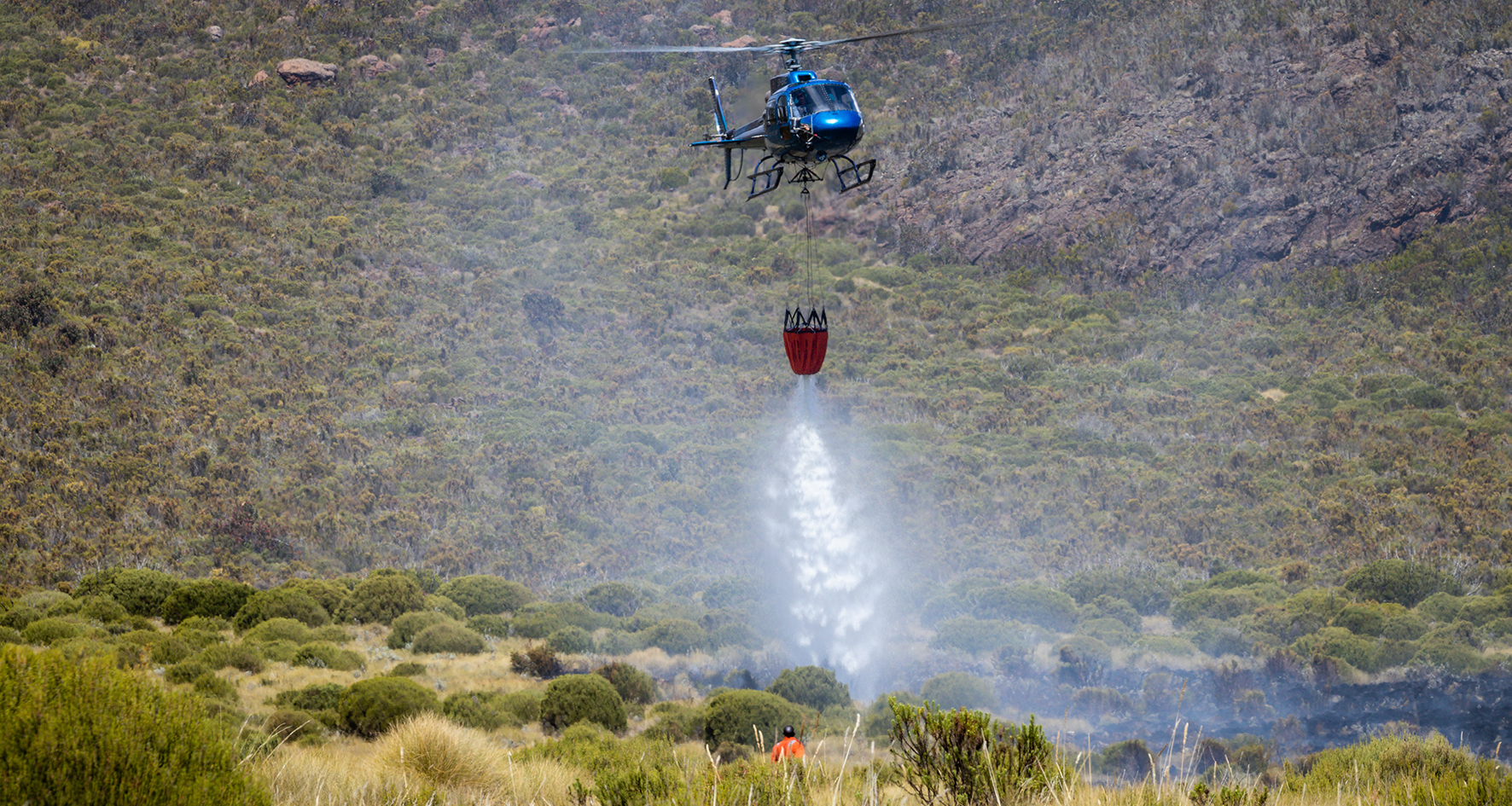 helicopter dropping water on fires, Mount Kenya